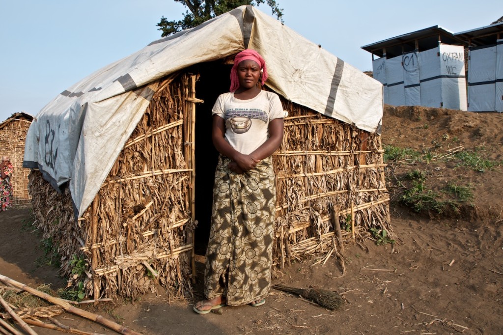 Young Sifa, 18 years old, in front of the shelter where she has been living with her parents since November 2012, in the Katale camp. Masisi, August 2013.