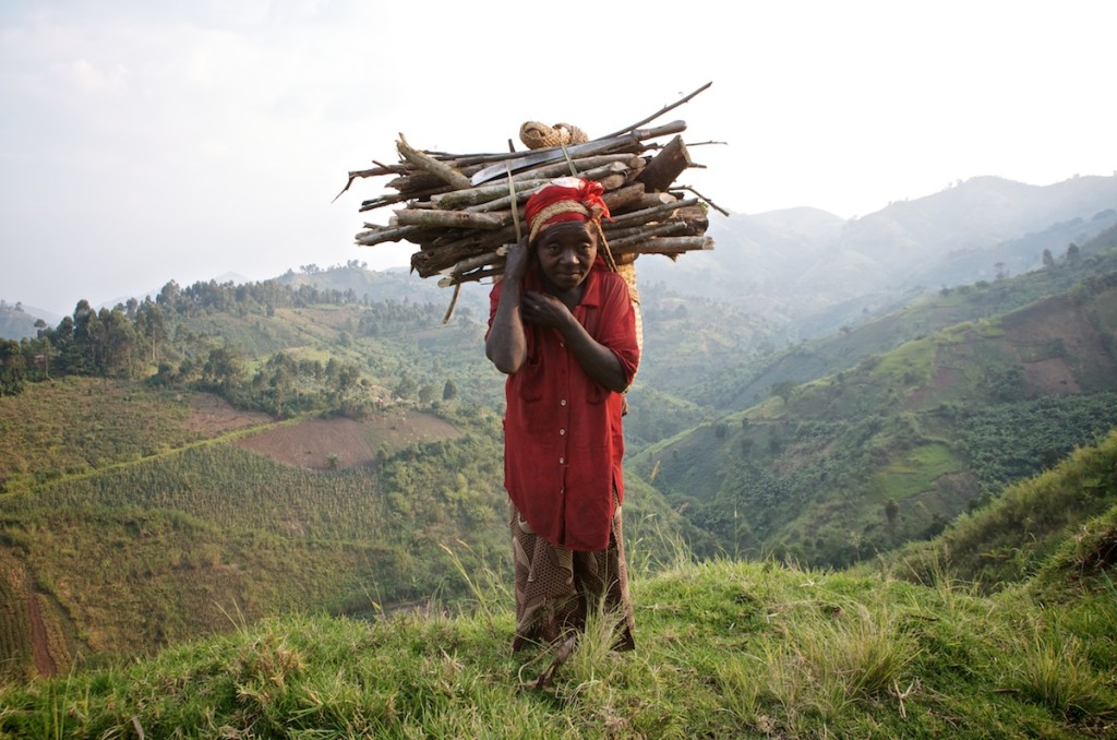 Maman Angelique has spent the whole day in the fields. At the end of the day, she goes home, overloaded with firewood which she will use to prepare food. Buabo group, Masisi territory, North Kivu, June 2013.