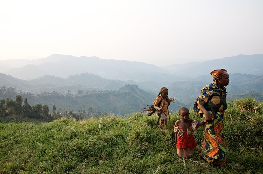 A woman and her two children go home after a day of working in the fields. Masisi, June 2013.